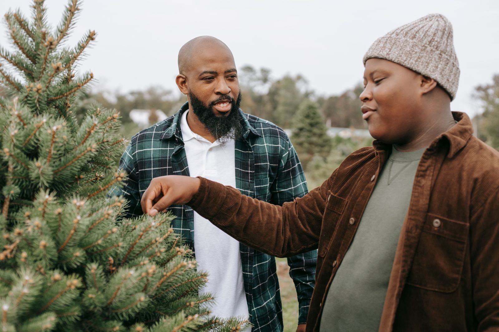 An adult mentor talking with a smiling teenage boy outdoors