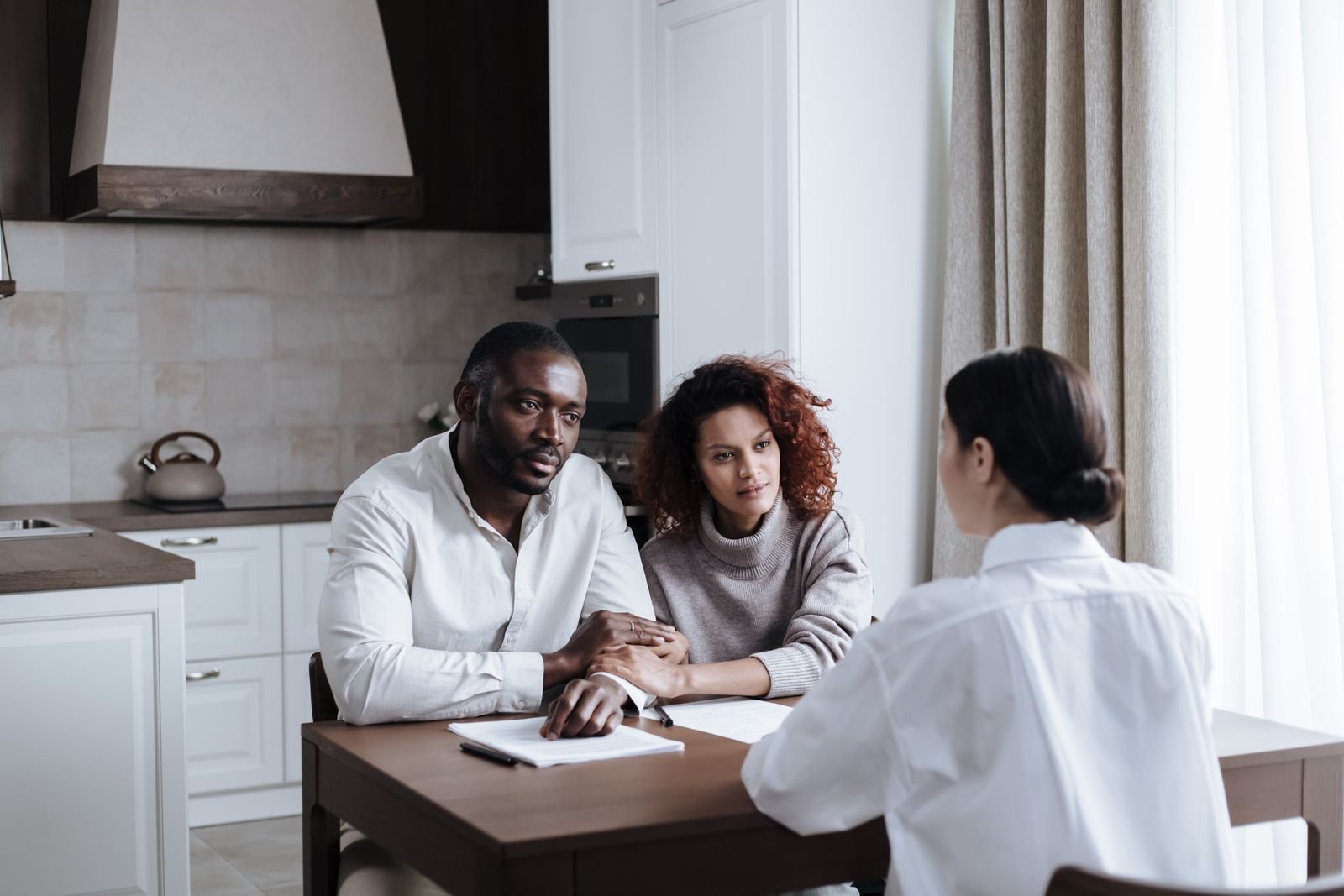 A professional meeting with family members around a kitchen table to talk through their questions